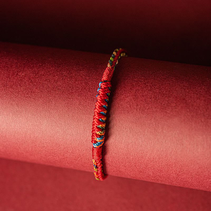 Multicolor thread bracelet shown on a neutral background